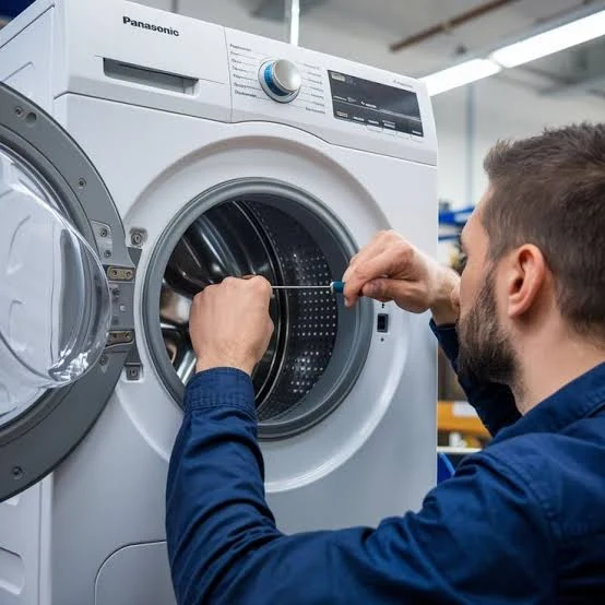 Technician working inside the drum of a front-loading washing machine